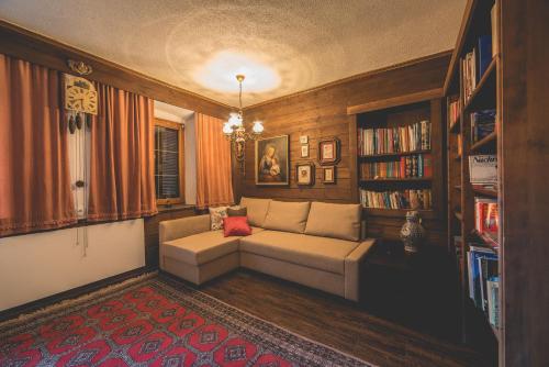 a living room with a couch and a book shelf at Schneggnheisl - Appartement in Sautens