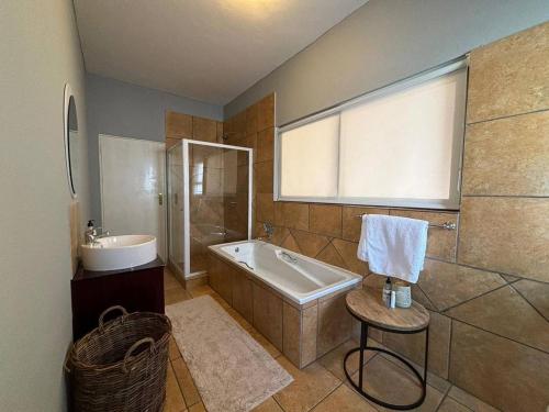 a large bathroom with a tub and a sink at Khenjadji at Fish Eagle Bay in Bela-Bela
