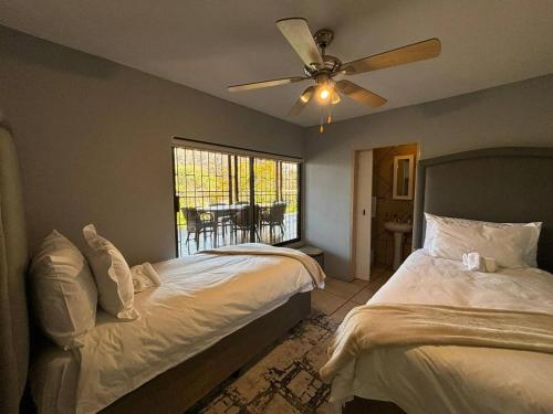 a bedroom with a bed and a ceiling fan at Khenjadji at Fish Eagle Bay in Bela-Bela