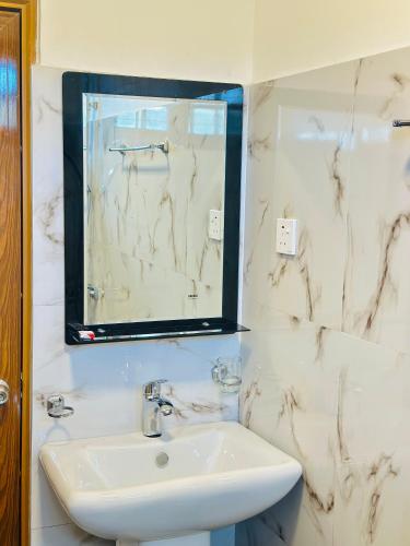 a bathroom with a sink and a mirror at travellers nest inn in Nuwara Eliya