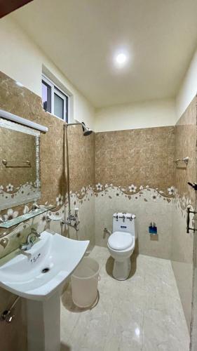 a bathroom with a white toilet and a sink at 2 Bed Apartment With View in Patriata