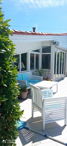 two white benches on a patio with a house at Les Ouilerres in Mervent