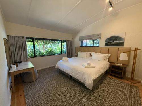 a bedroom with a large white bed and a window at Twice Central Guest House in Stellenbosch