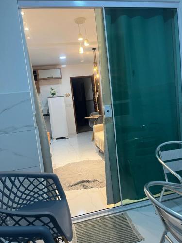 a room with a sliding glass door with a table and chairs at Apartamento Frente Mar in Jacumã