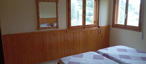 a bedroom with two beds and two windows at villa Garibaldi in Agüero