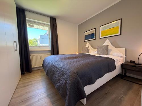 a bedroom with a bed and a large window at Käpt'n Gordon, App 2 in Wenningstedt