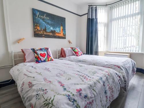 a bedroom with two beds and a painting on the wall at Ince House in Liverpool