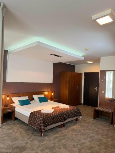 a large bedroom with a large bed with blue pillows at Pokoje Hotel Diva 200 metrów do plaży in Kołobrzeg