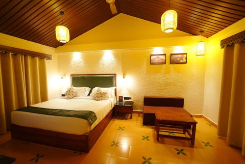 a bedroom with a large bed and a table at Anaasa Resorts in Tiruvannāmalai