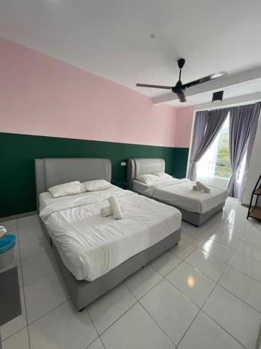 a bedroom with two beds and a ceiling fan at V Cozy Homestays in Brinchang