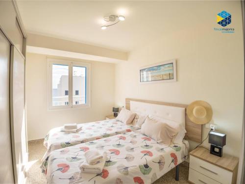 a bedroom with two beds and a window at Apartamento Rocamar in S'Illot