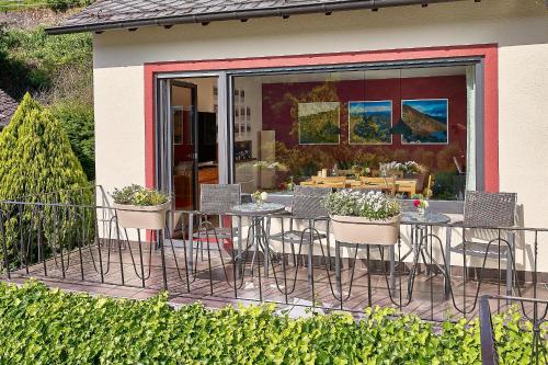 a patio with chairs and a table with flowers at Wohnen am Weingut - Bei den Weinbergen in Briedel