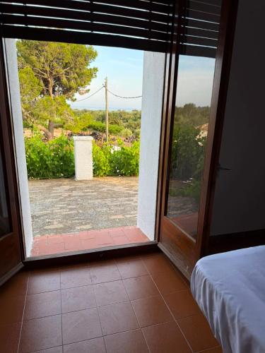 a door to a room with a view of a yard at Masia Garridells in L'Ampolla