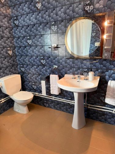 a bathroom with a sink and a toilet and a mirror at Masia Garridells in L'Ampolla