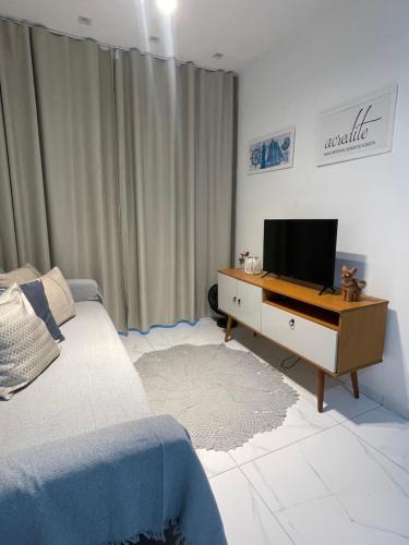 a bedroom with a bed and a tv on a dresser at Apartamento Frente Mar in Jacumã