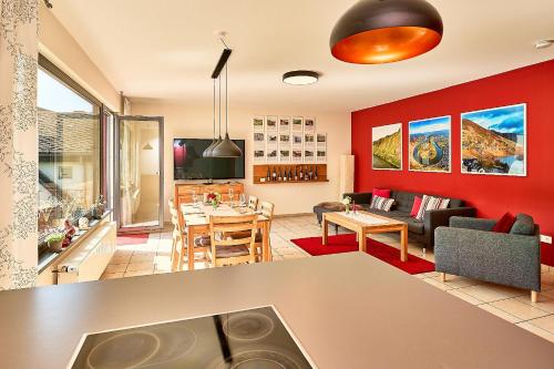 a kitchen and living room with red walls at Wohnen am Weingut - Bei den Weinbergen in Briedel
