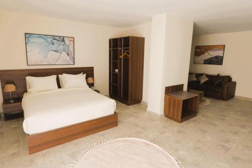 a bedroom with a bed and a chair and a couch at Settle inn Jebal apartments in Cairo