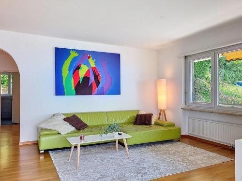 a living room with a green couch and a table at Apartment Apt-Woka by Interhome in Aldesago