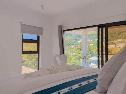 a bedroom with a bed with a large window at Cove Holiday Apartments in Bel Ombre