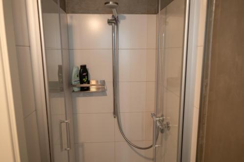 a bathroom with a shower with a glass door at Goslar LIVING 1 - Modern & Zentral in Goslar