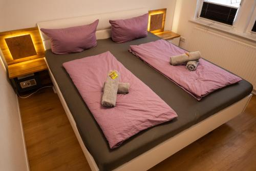 a bed with two pillows and two towels on it at Goslar LIVING 1 - Modern & Zentral in Goslar