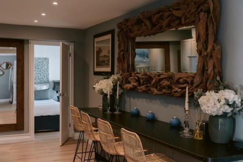 a room with a table with chairs and a mirror at The Hamptons Beach House in East Preston