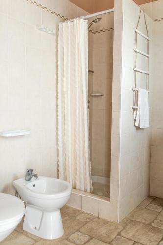 a bathroom with a toilet and a sink and a shower at B&B La Vigna in Carovigno