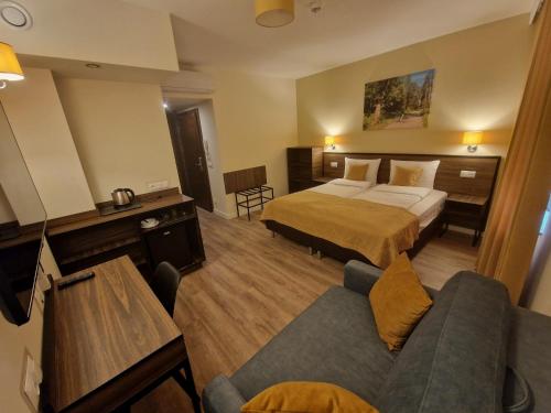 a hotel room with a bed and a couch at Apart Home Tel AHT in Krapkowice
