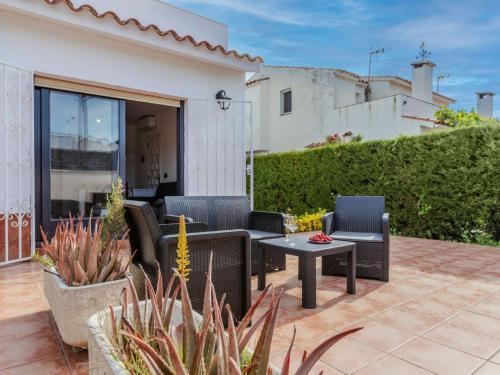 a patio with chairs and a table in front of a house at Villa Calas III by Interhome in L'Ametlla de Mar