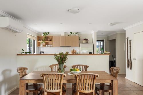 a kitchen and dining room with a wooden table and chairs at Villa 11 Margaret River Beach House in Margaret River Town