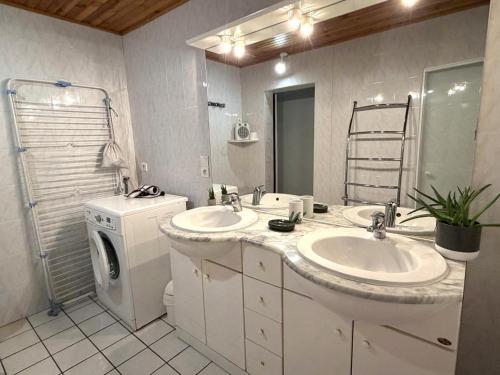 a bathroom with two sinks and a washer and dryer at Au gat in Léon