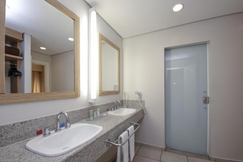 uma casa de banho com 2 lavatórios e um chuveiro em Rio Quente Cristal Resorts em Rio Quente