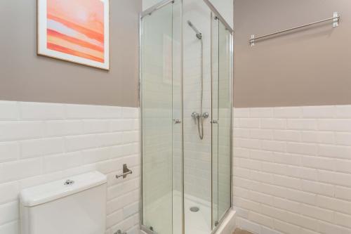 a glass shower in a bathroom with a toilet at Barbieri III in Madrid