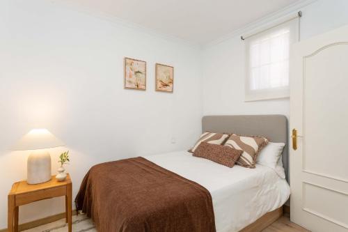 a white bedroom with a bed and a window at Barbieri III in Madrid