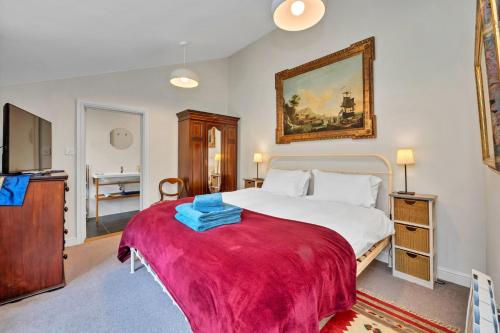 a bedroom with a large bed with a red blanket at Finest Retreats - The Pottage in Yaxley