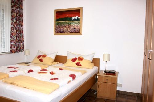 two beds in a hotel room with flowers on the sheets at Haus Witten Höhen Ferienwohnungen in Cuxhaven