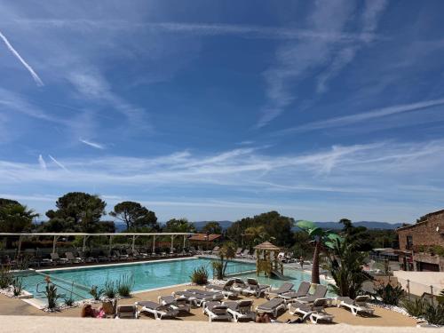 a pool with chaise lounges and lounge chairs at Chez Yoyo Mobil-home tout confort pour des vacances inoubliables in Saint-Raphaël