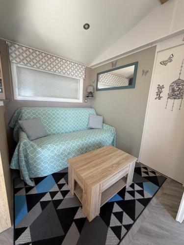 a small living room with a couch and a table at Chez Yoyo Mobil-home tout confort pour des vacances inoubliables in Saint-Raphaël