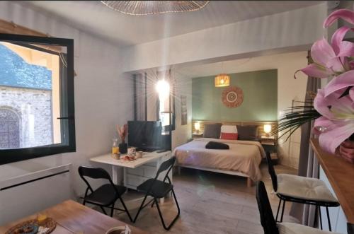 a hotel room with a bed and a table and chairs at Le Studio Fouesnantais in Fouesnant