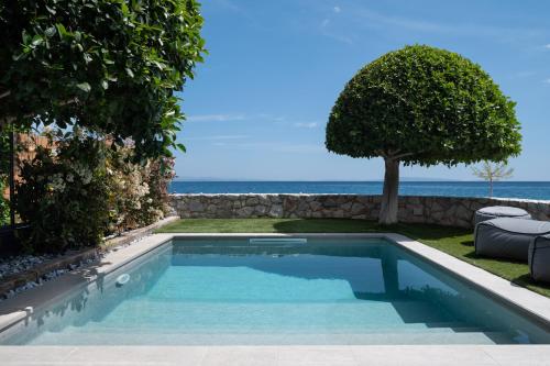 a swimming pool with the ocean in the background at Tyros Boutique Houses Villas in Tyros