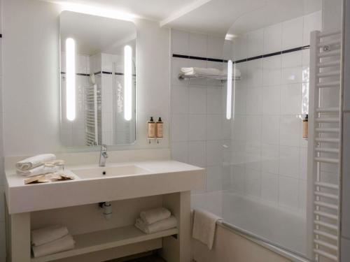 a white bathroom with a sink and a shower at Mercure Rouen Centre Cathédrale in Rouen