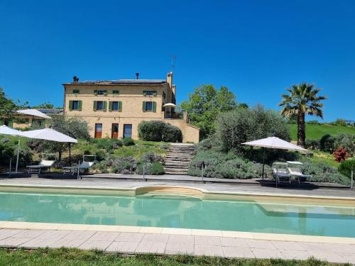 a house with a swimming pool in front of a building at Casal dei Fichi in Francavilla dʼEte