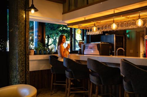 a woman standing at a bar in a restaurant at Radisson Hotel Cape Town Foreshore in Cape Town