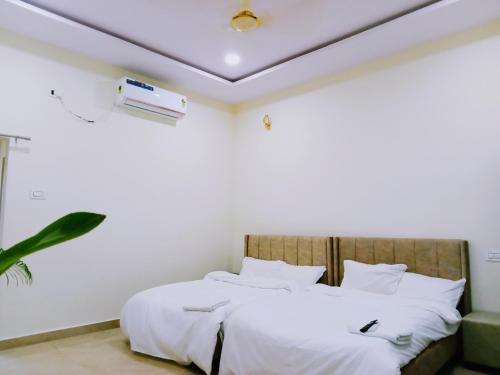 a bedroom with a bed with white sheets at Mega Grand Rooms in Narasaraopet