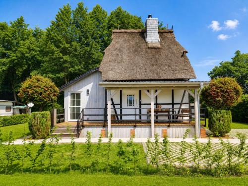 a cottage with a thatched roof in a garden at Ferienwohnungen Dümmersee - Hexenhaus in Hüde
