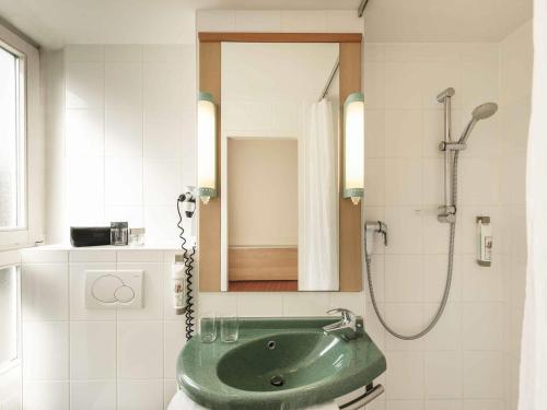 a bathroom with a green sink and a shower at ibis Bamberg Altstadt in Bamberg