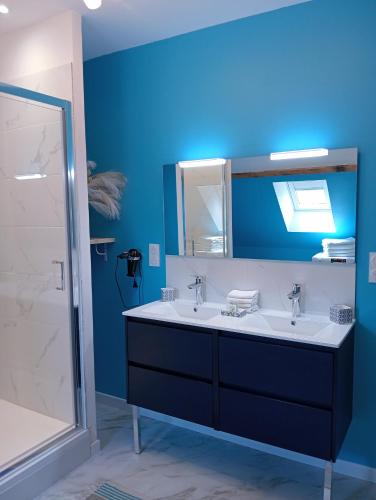 a bathroom with two sinks and a blue wall at L'entre-potes in Sully-sur-Loire