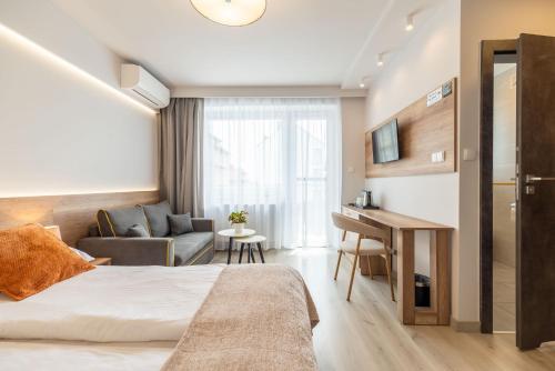 a hotel room with a bed and a desk at Villa Baltica II in Rewa
