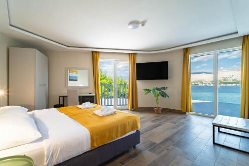 a bedroom with a bed and a view of the ocean at Hotel Plaza in Pag