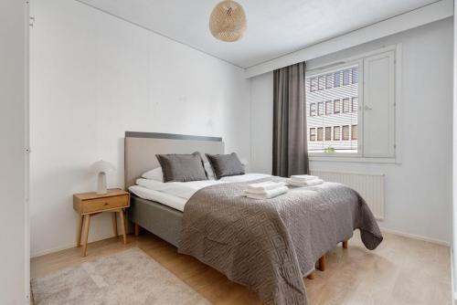 a white bedroom with a bed and a window at Central Lapland Apartment By Lapland Host in Rovaniemi